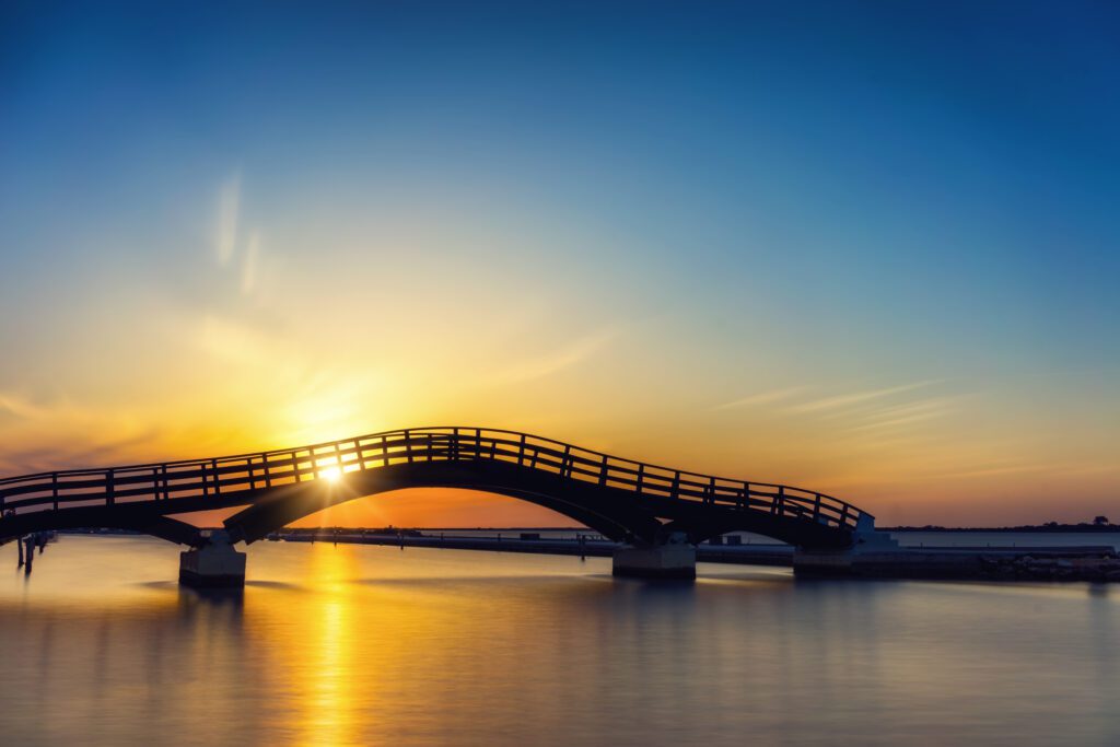 Brücke vor Sonnenaufgang. Dieser Artikel soll einen Brückenschlag zwischen gelebtem Leben und Wissenschaft erzielen. Genau das, was sowohl Ersatzkinder als auch Menschen in Beraternden und therapeutischen Berufen, Wissenschaft und Forschung weiterbringt.